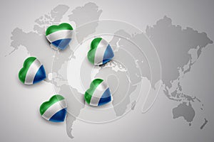 Five hearts with national flag of sierra leone on a world map background.