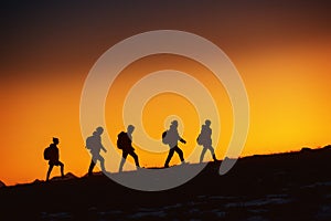 Five hikers going uphill at sunset