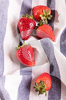 Five juicy strawberry on kitchen cloth