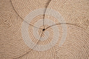 Five jute rope placemats arranged in a star shape, abstract texture backdrop