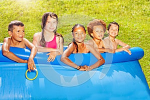 Five kids friends portrait on swimming pool border