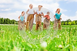 Five kids having fun jumping in sacks