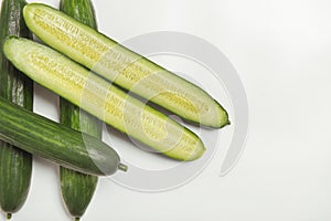 Five long green cucumbers on white background close