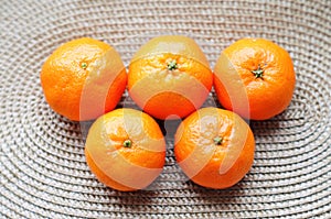 Five mandarins are laid out on a mat in the form of Olympic rings