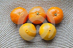 Five mandarins are laid out on a mat in the form of Olympic rings