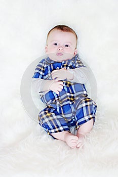 Five-months baby lies on a fur plaid