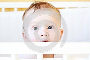 Five-months baby in white bed