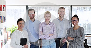 Five multicultural ambitious employees photoshoot stand in coworking office