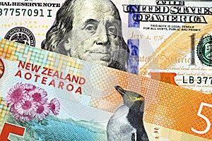 A five New Zealand dollar bill close up with an American one hundred dollar bill