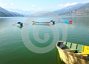 Five nice multicolore tourist boats of Lake Pheva, mountains and clouds