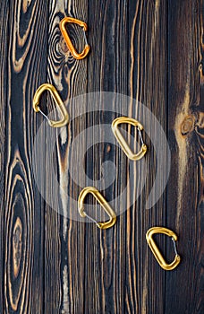 Five objects. Isolated photo of climbing equipment. Parts of carabiners lying on the wooden table