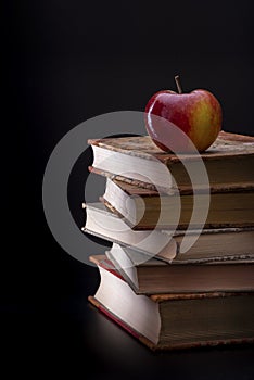 Five old books with an apple