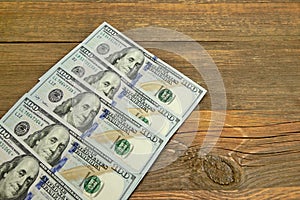 Five One Hudred Dollar Bill On The Rough Wood Background