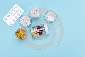 Five packs with various pills on a blue background. Health concept.