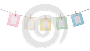 Five paper photo frames hanging on the rope isolated on white background