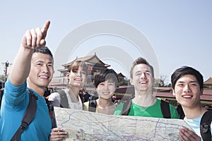 Five people looking at map with Tiananmen Square in background.