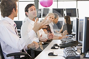 Five people in an office throwing a ball around