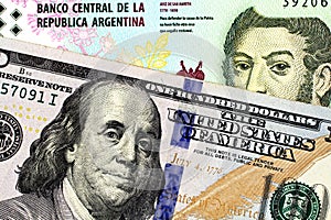 A five peso bank note from Argentina with an American one hundred dollar bill