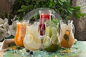 Five pitcher with colorful lemonade on the table