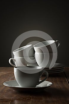 Five plain white ceramic coffee or tea cups