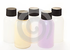 Five plastic bottles of coloured liquid