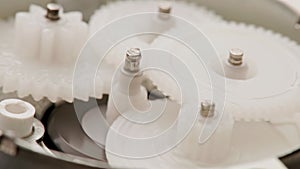 five plastic gears rotate in mutual mesh inside a small reduction gear