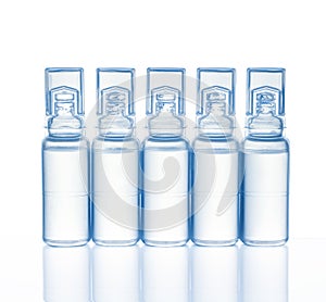 Five plastic medical ampoules with reflection, isolated on a white background