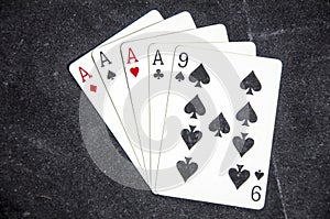 Five playing card`s a hand of a four of a kind ace`s and a nine