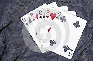 Five playing card`s A hand of a four of a kind eight`s and a four