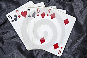 Five playing card`s A hand of a four of a kind five`s and a four