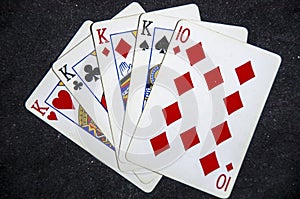 Five playing card`s a hand of a four of a kind king`s and a ten