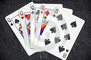 Five playing card`s a hand of a four of a kind queens and a eight