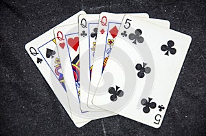 Five playing card`s a hand of a four of a kind queens and a six