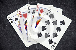 Five playing card`s a hand of a four of a kind queens and a ten