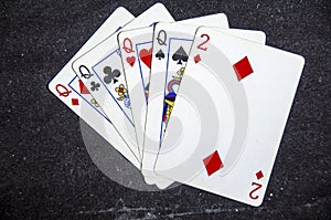 Five playing card`s a hand of a four of a kind queens and a two