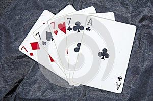 Five playing card`s A hand of a four of a kind seven`s and a ace