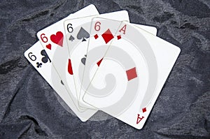 Five playing card`s A hand of a four of a kind six`s and a ace