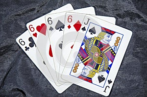 Five playing card`s A hand of a four of a kind six`s and a jack