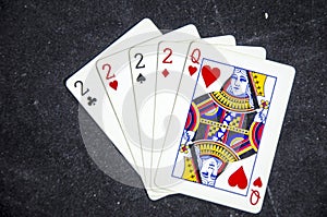 Five playing card`s a hand of a four of a kind two`s and a queen