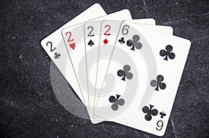 Five playing card`s a hand of a four of a kind two`s and a six