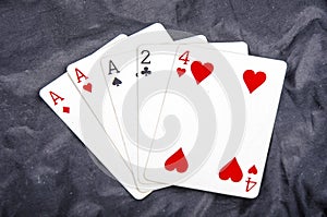 Five playing card`s a hand of a three of a kind two and a four