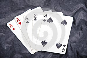 Five playing card`s a hand of a three of a kind two and a four