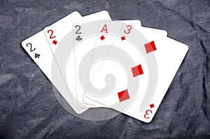 Five playing card`s a hand of a three of a kind two`s and a ace and a three