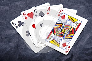 Five playing card`s stud hand three of a kind six and ace a king fun