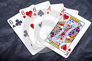 Five playing card`s stud hand three of a kind six and ace a king fun