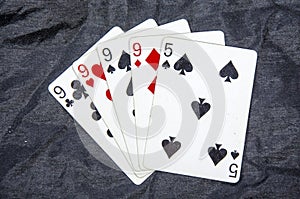 Five playing cards four of a kind nine`s and a five