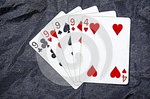 Five playing cards four of a kind nine`s and a four