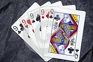 Five playing cards four of a kind nine`s and a queen