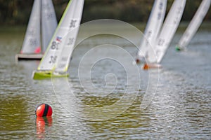 Five radio controlled yachts, racing towards a buoy.