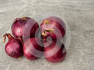 Five red onions on gray. Selective focus